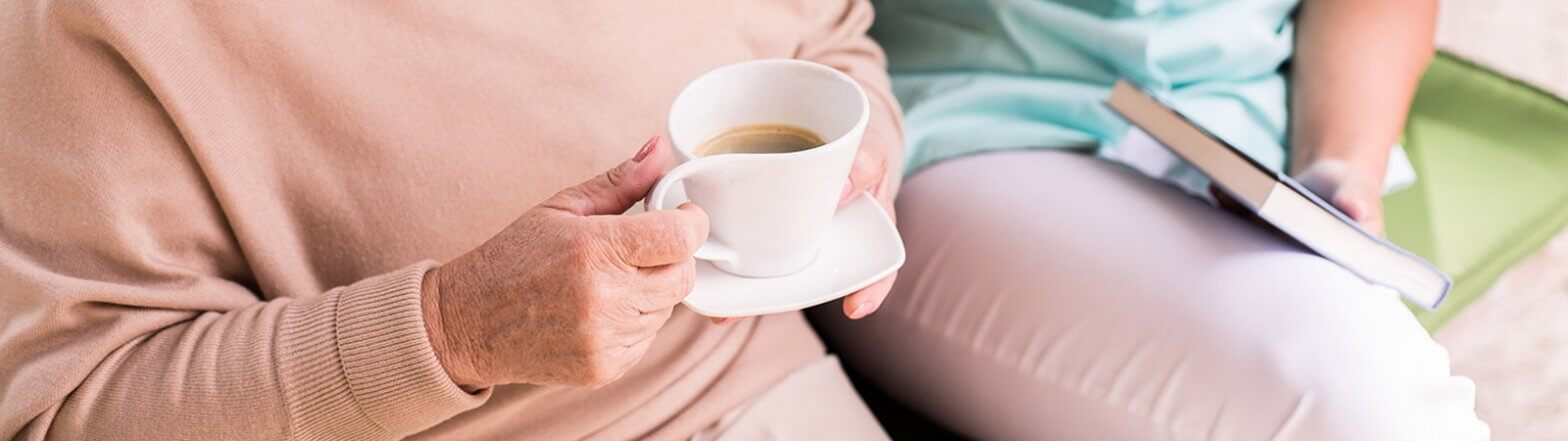 Seniorin trinkt in Essen Kaffee mit Haushaltshilfe